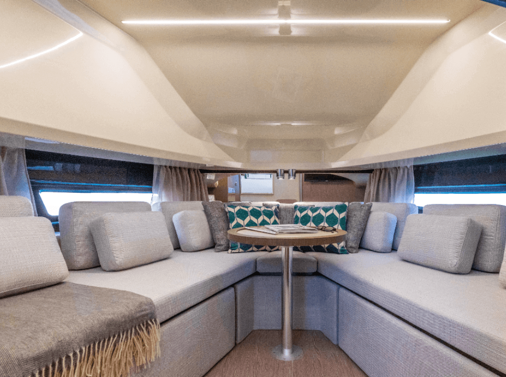 Invictus TT430S America below deck living area with U-shaped sofa that converts to a double bed