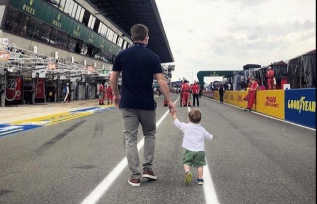 Michael Young with his child walking by raceway