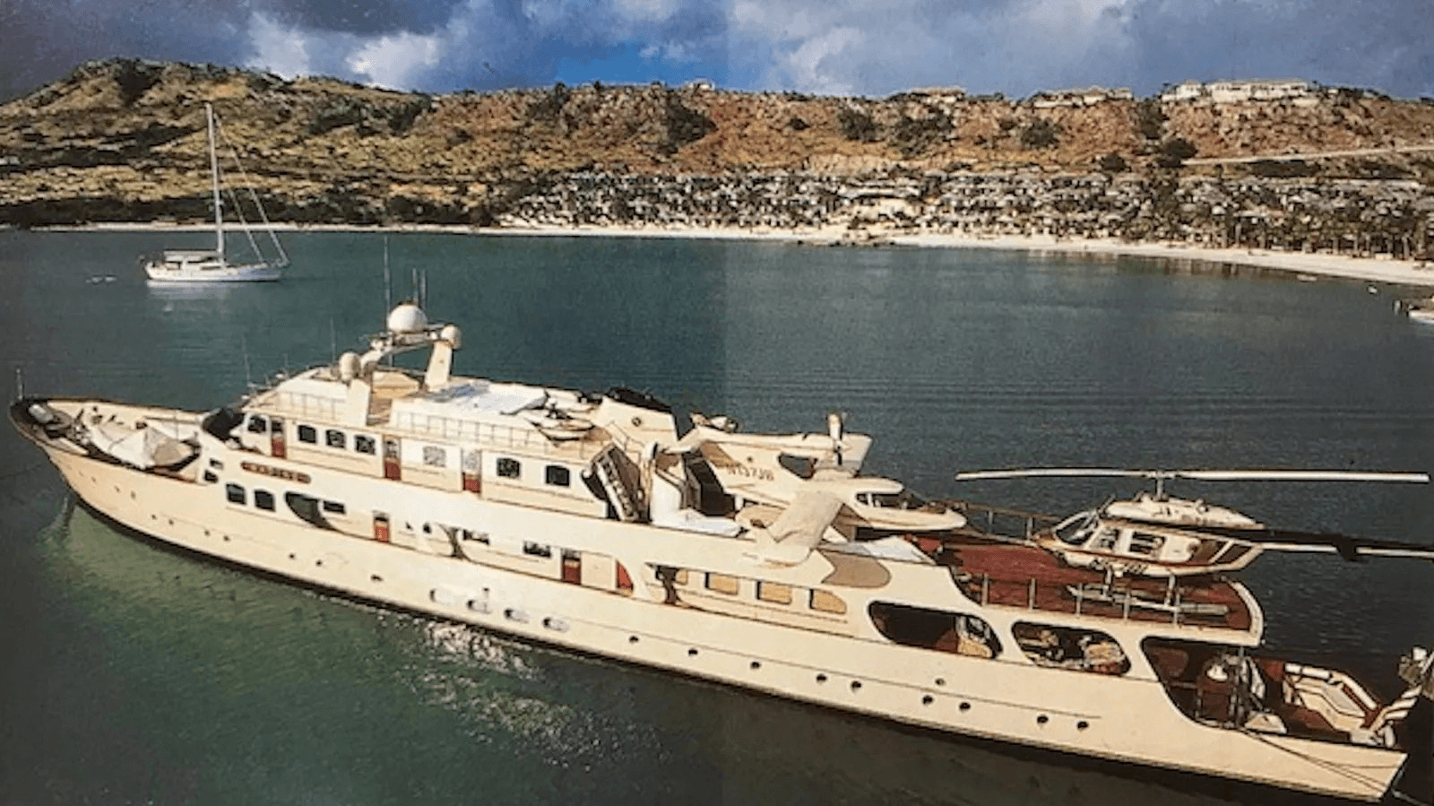 Superyacht Nadine in a bay with mountains in the background