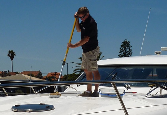 Washing a boat, cleaning the topsides, long-handled boat brush