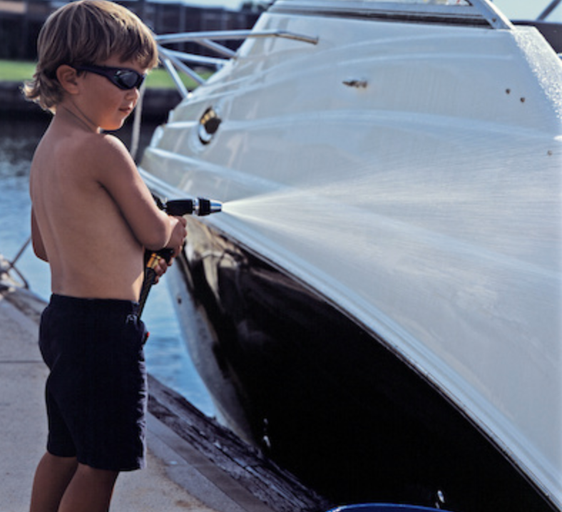 washing a boat, kid washing a boat, cute kid with a hose
