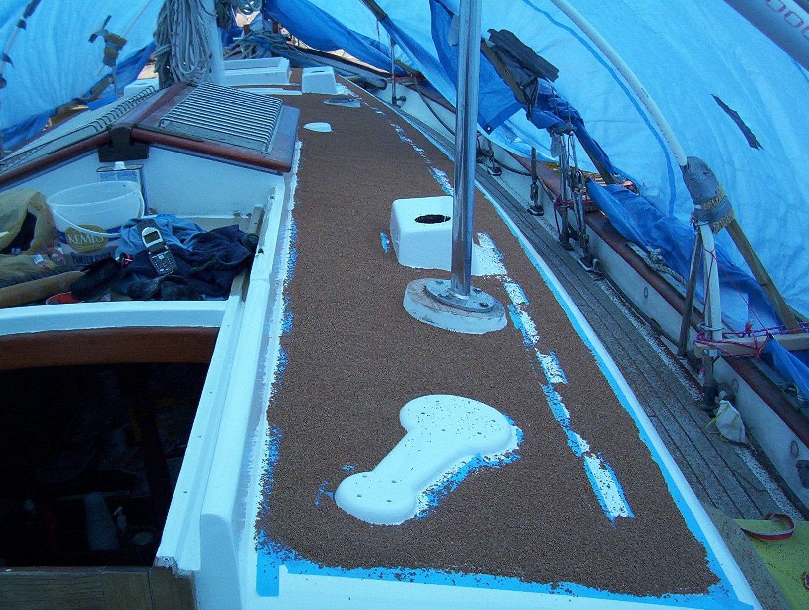 Crushed walnut shells being applied to wet deck paint