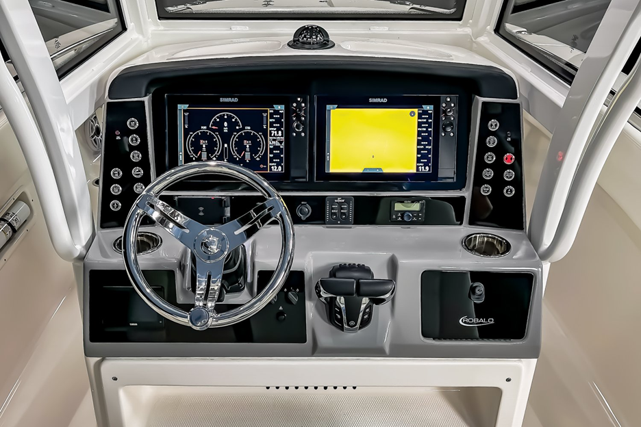 This close-up of the helm shows the convenient layout with all controls and switches within easy reach. The waterproof breakers are located just below the throttles and note the deep walk-around to each side of the console.