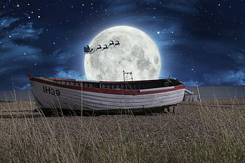 Santa flying by moon over a boat
