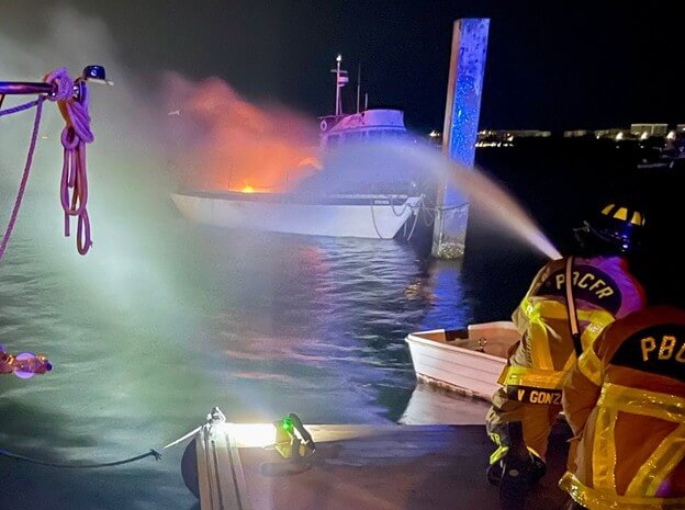 Burning boat being extinguished by a fire boat