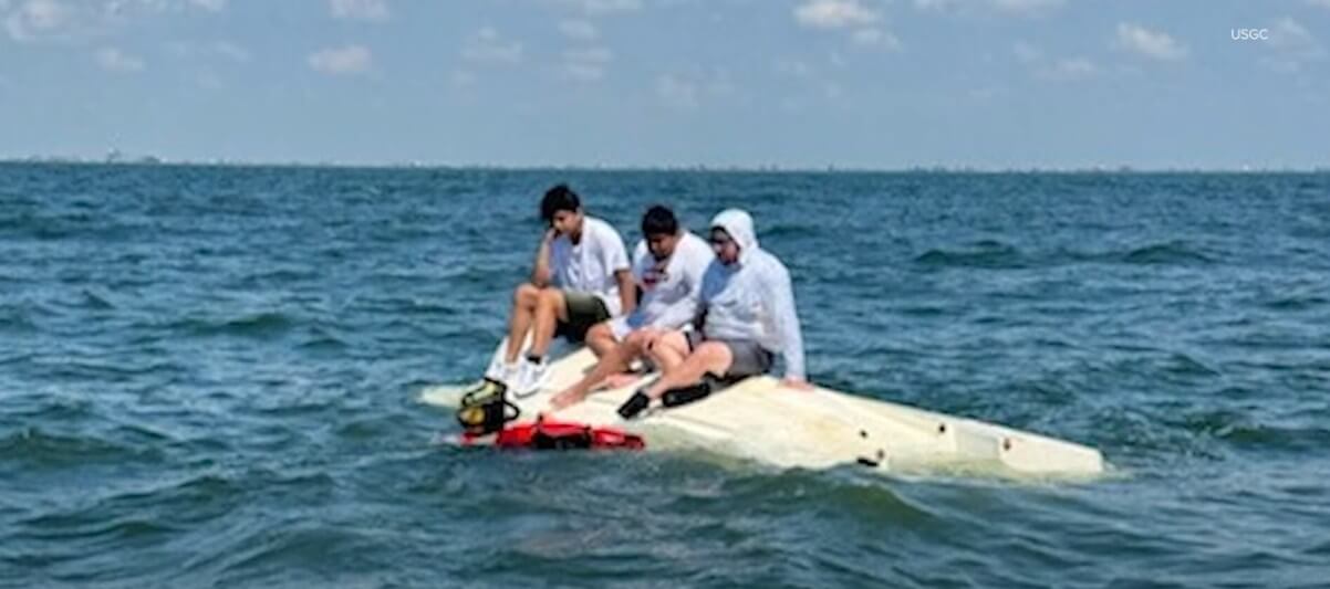 3 Men on Top of Capsized Boat