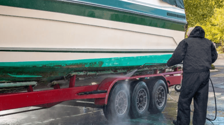 person rinsing a boat with water