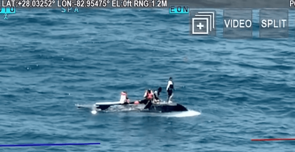 People standing on overturned boat