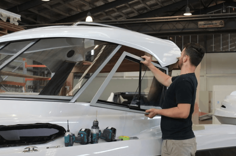 man glazing windows on a boat