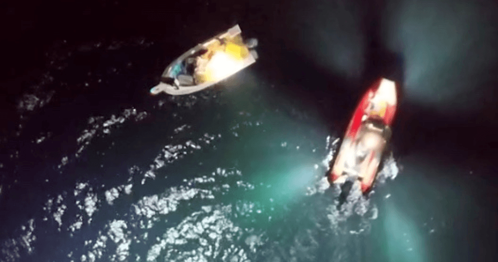 Two boats at night in water