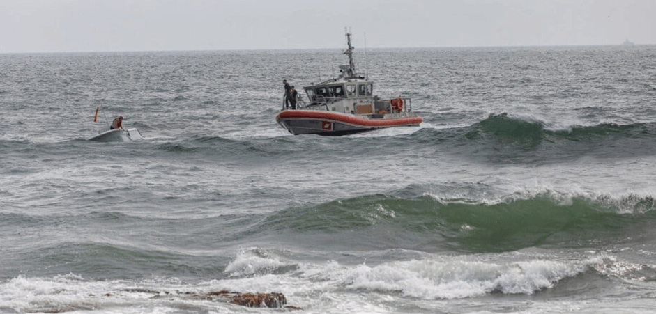 Boat rescuing a man in capsized boat