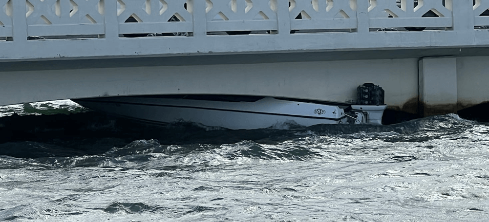 Boat wedged under a bridge