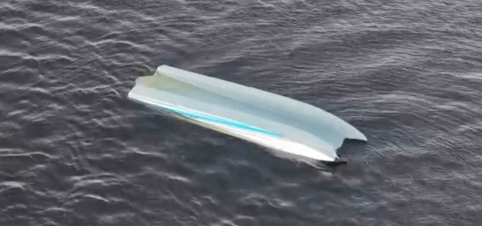 Catamaran filled upside down in water.