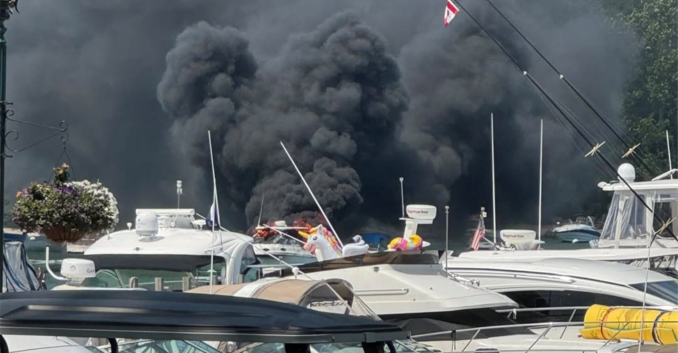 Boat on fire with black smoke over it