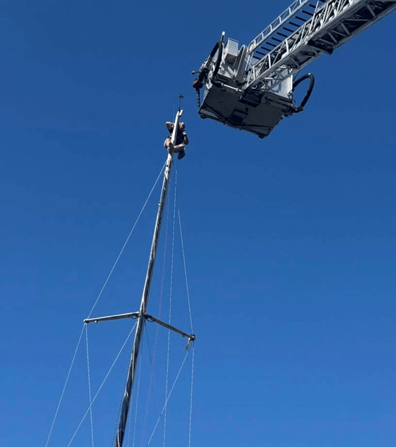 Man on top of a Sailboat Mast