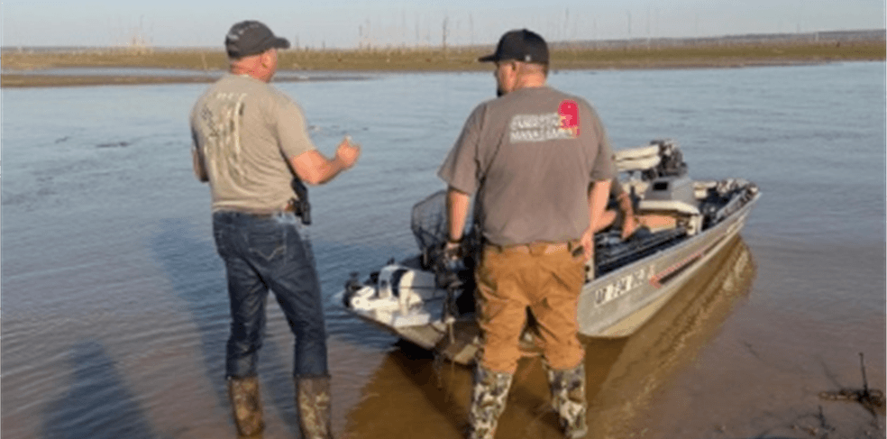 Two men standing in low water