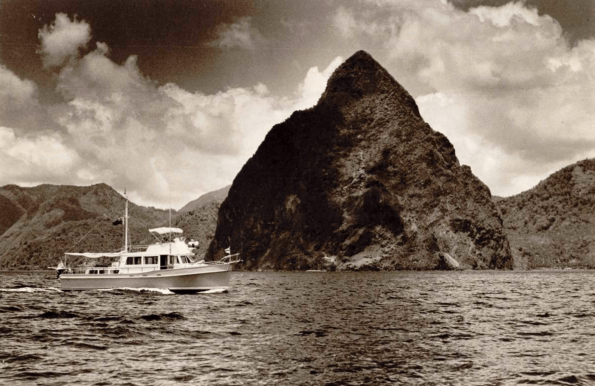 historical photo of boat running in front of mountains