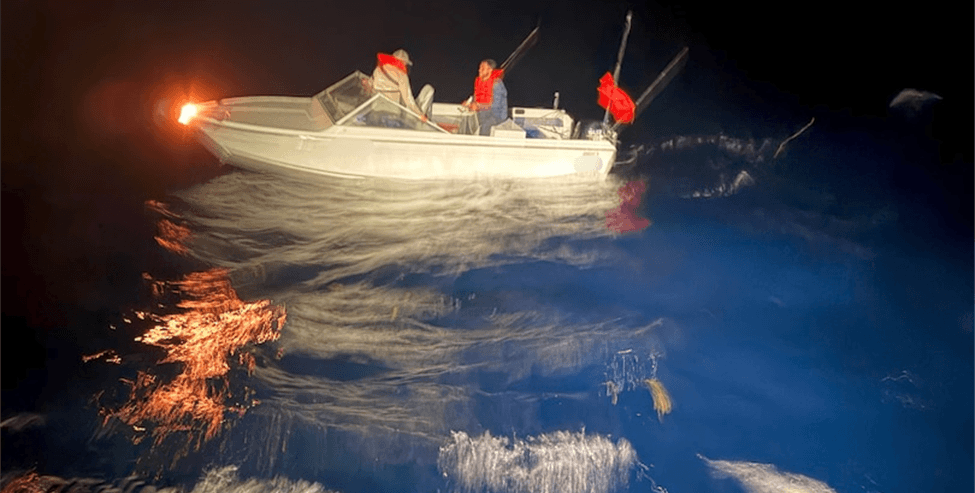 2 men in a boat at night