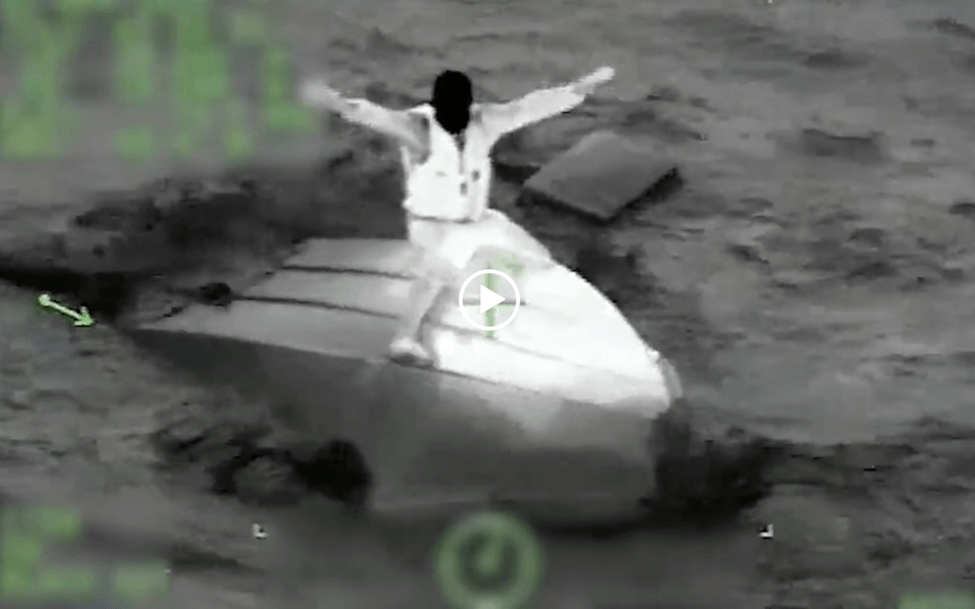 Man sitting on a capsized boat