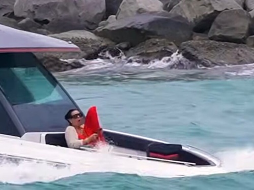 people on boat getting hit with waves