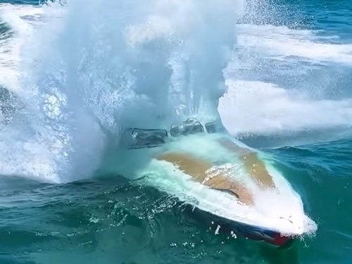 boat skimming underneath a wave