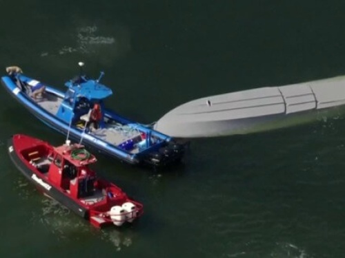 2 tow vessels trying to upright a submerged vessel